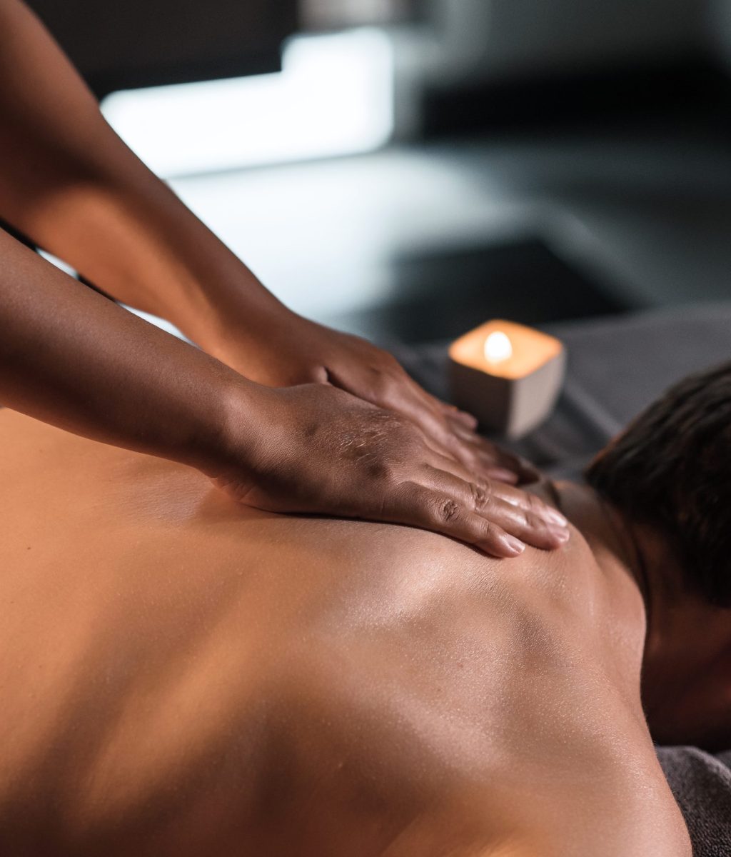 Masseur doing neck massage of man in oriental spa